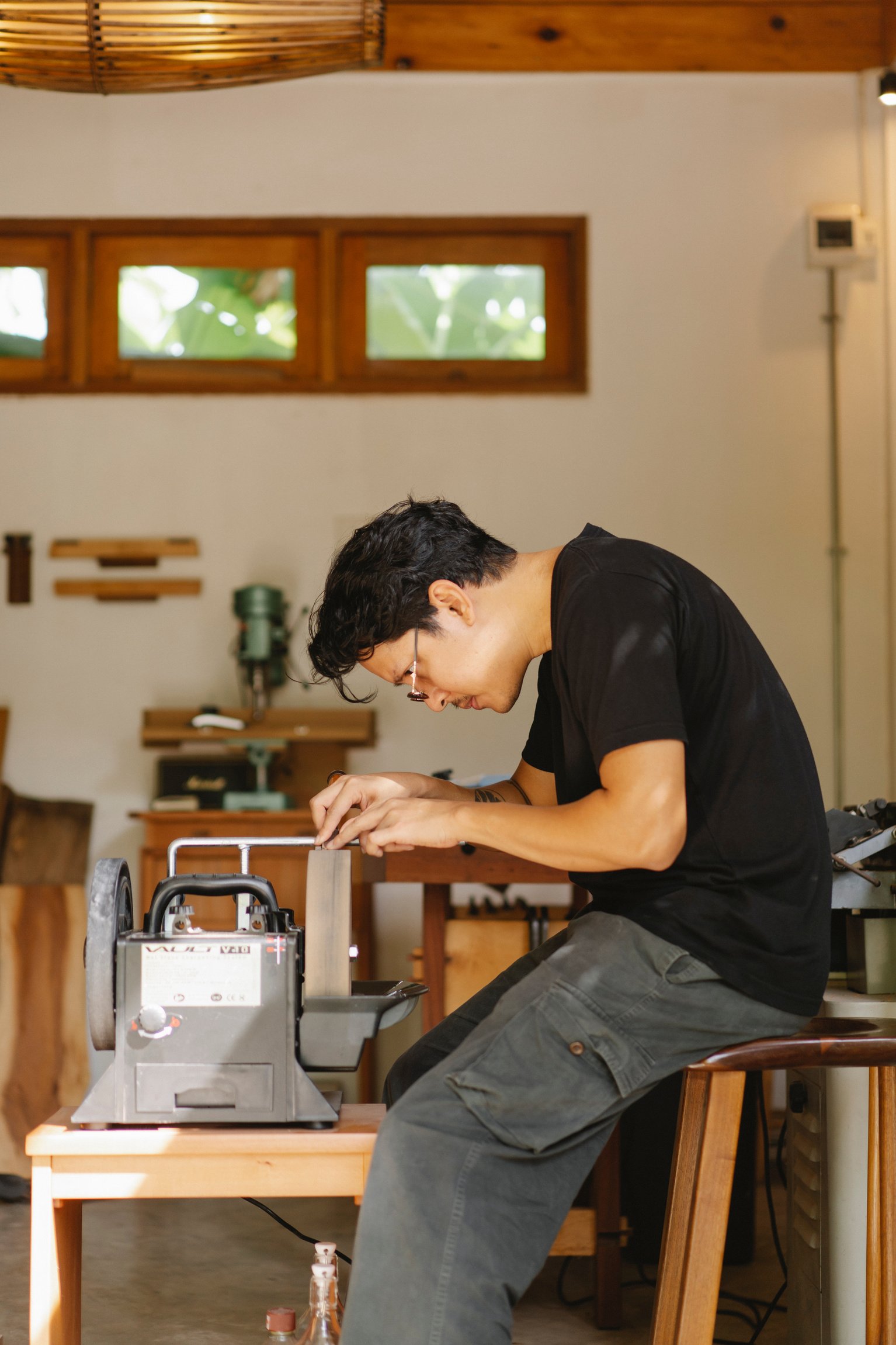 Concentrated ethnic artisan at sharpening machine